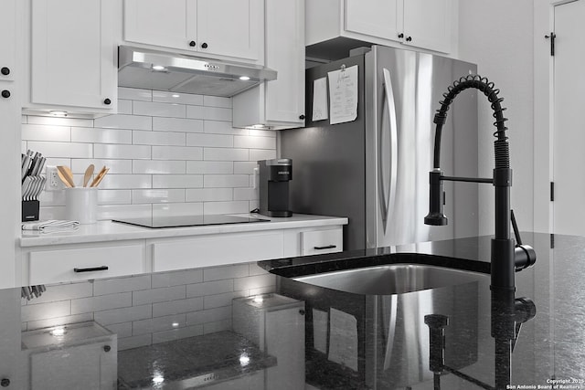 kitchen with under cabinet range hood, backsplash, white cabinetry, and black electric stovetop