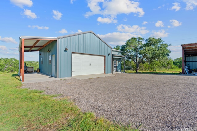 garage with a detached garage and gravel driveway