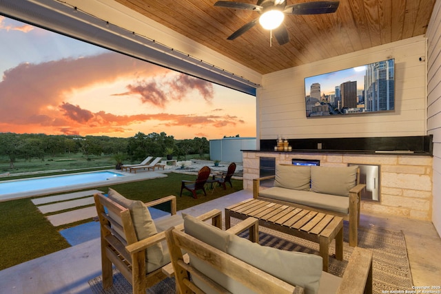 view of patio featuring outdoor lounge area, a swimming pool, a ceiling fan, and an outdoor kitchen