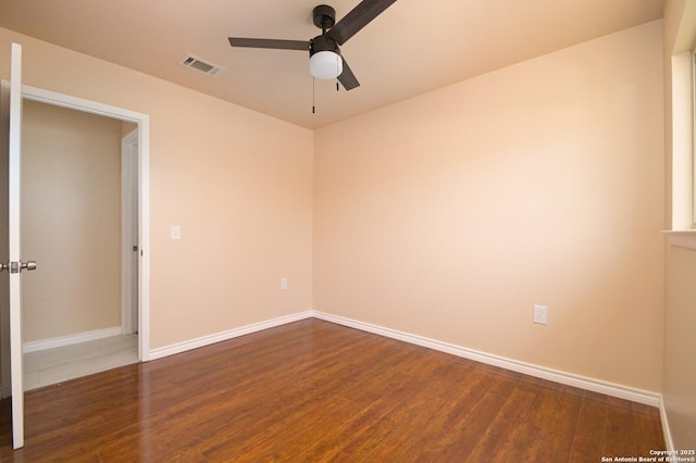 spare room with visible vents, baseboards, and wood finished floors