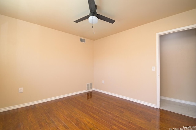 empty room with visible vents, baseboards, dark wood-type flooring, and ceiling fan