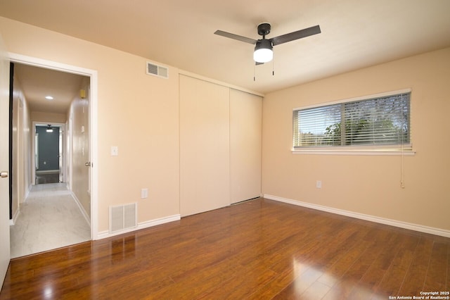 empty room featuring visible vents, baseboards, and wood finished floors