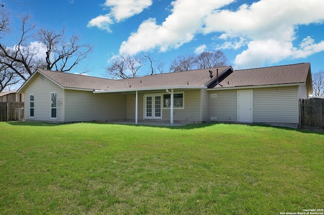 rear view of property featuring a lawn, french doors, a patio, and fence