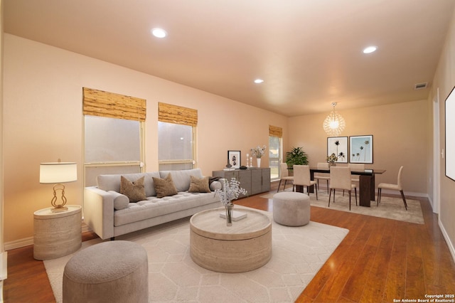 living area featuring recessed lighting, visible vents, baseboards, and wood finished floors