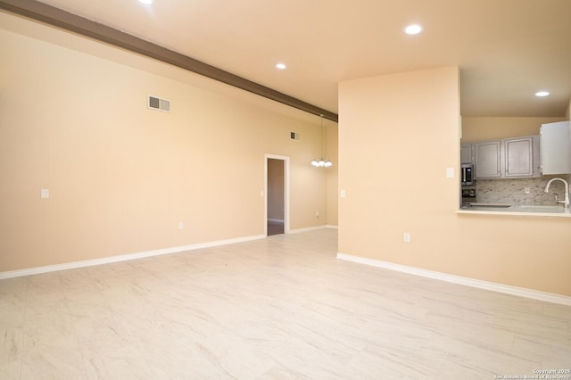 unfurnished living room with recessed lighting, baseboards, visible vents, and a sink