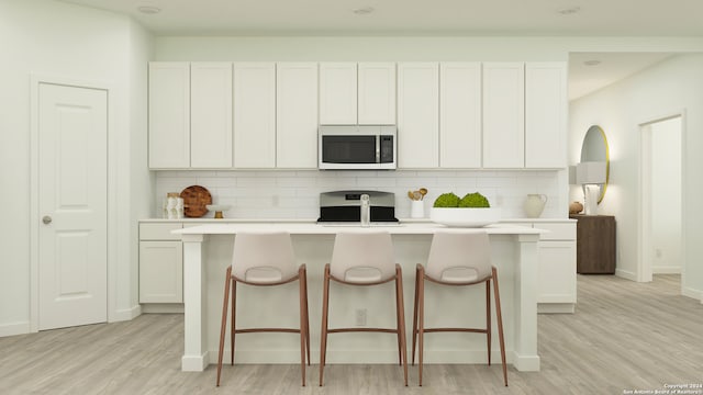 kitchen featuring stove, light wood-style flooring, light countertops, and backsplash