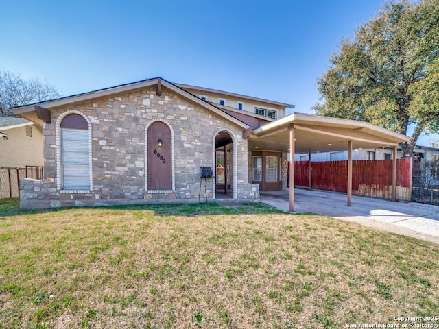 view of front facade featuring an attached carport, driveway, a front lawn, and fence