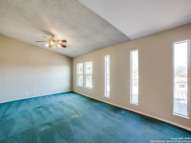 unfurnished room featuring carpet flooring, a textured ceiling, baseboards, and vaulted ceiling