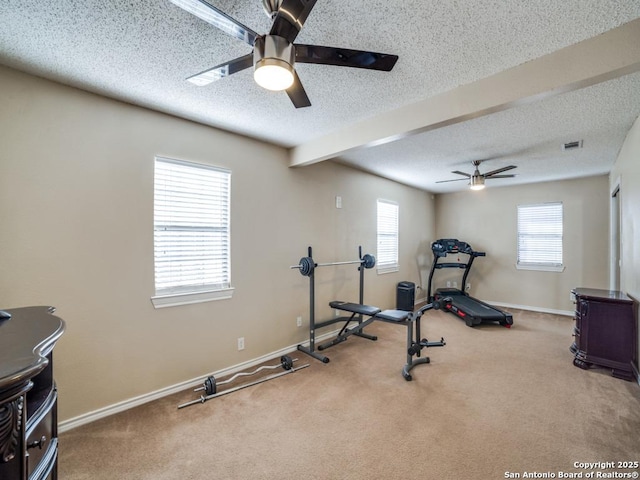 workout room featuring a ceiling fan, carpet, baseboards, and a textured ceiling