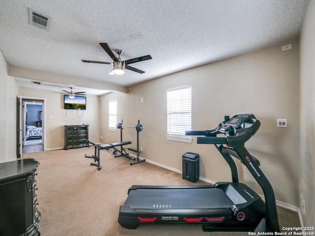 exercise area featuring carpet, baseboards, visible vents, ceiling fan, and a textured ceiling