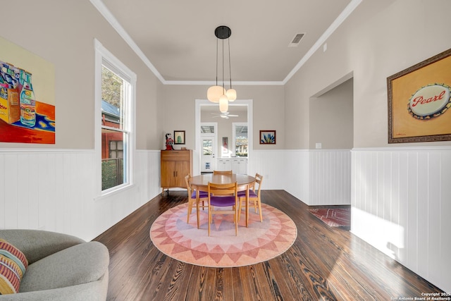 dining room with ornamental molding, dark wood-style floors, visible vents, and wainscoting