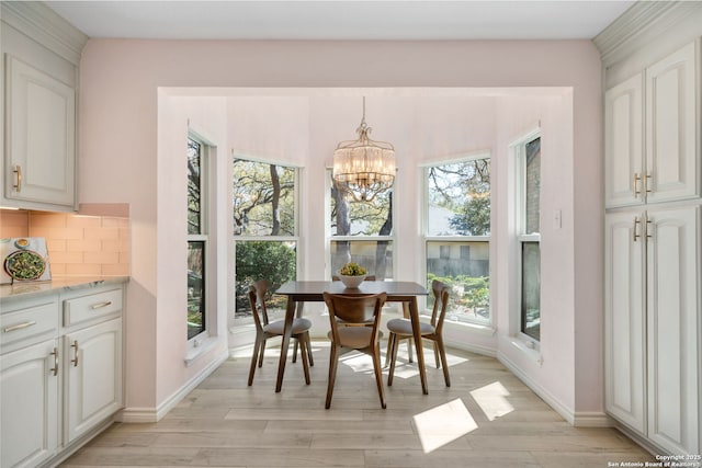 dining space featuring a notable chandelier, light wood-style floors, and baseboards