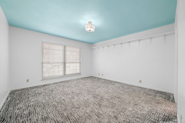 unfurnished room with baseboards and carpet