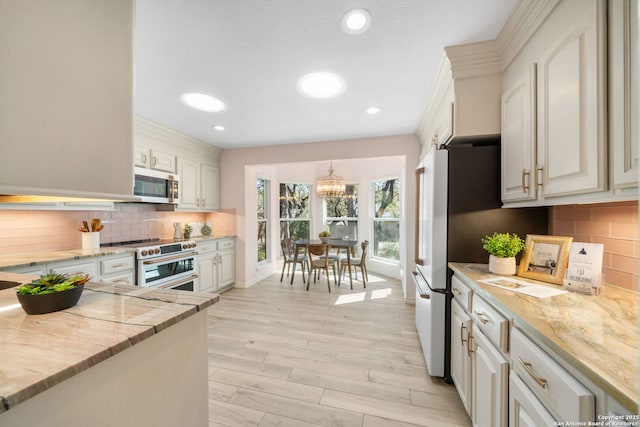 kitchen featuring light stone counters, tasteful backsplash, recessed lighting, white appliances, and light wood finished floors