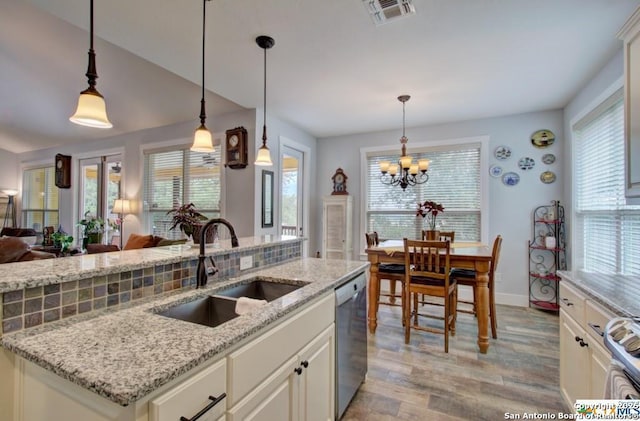 kitchen featuring visible vents, light wood-style flooring, a sink, appliances with stainless steel finishes, and open floor plan