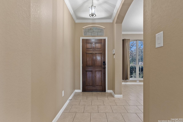 foyer entrance with light tile patterned floors, baseboards, ornamental molding, and a textured wall