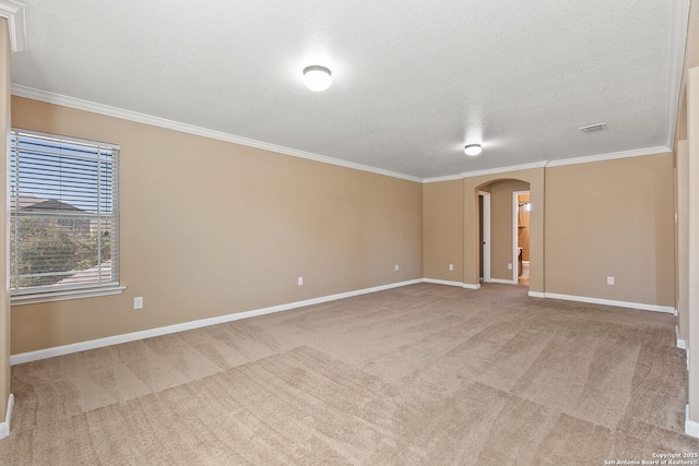 unfurnished room featuring visible vents, arched walkways, ornamental molding, and carpet flooring