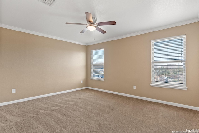 carpeted empty room with ceiling fan, visible vents, baseboards, and ornamental molding