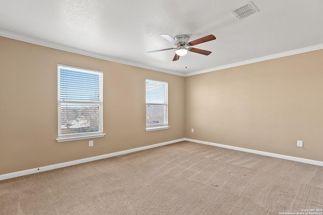 spare room featuring crown molding, light colored carpet, visible vents, and baseboards