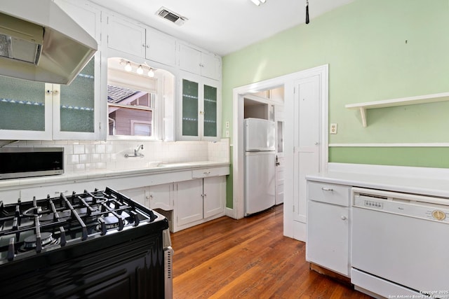 kitchen with visible vents, range hood, white appliances, and white cabinets