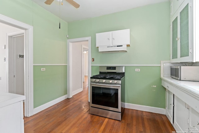 kitchen with dark wood finished floors, white cabinets, under cabinet range hood, and stainless steel appliances