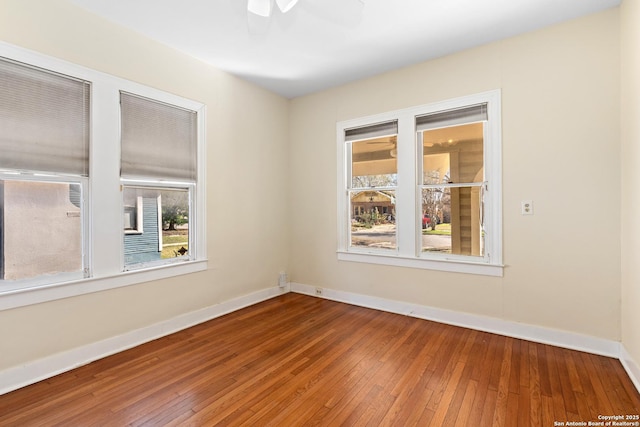 spare room with a ceiling fan, baseboards, and hardwood / wood-style flooring