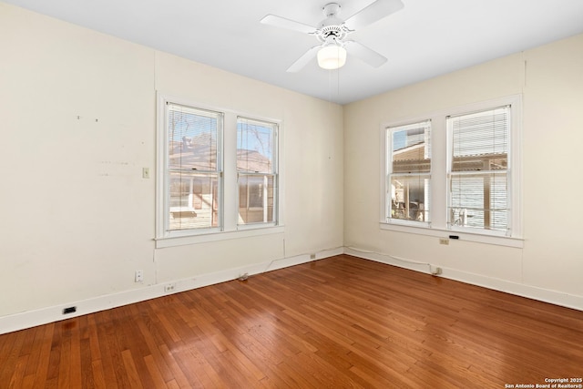 spare room featuring hardwood / wood-style floors, a ceiling fan, and baseboards