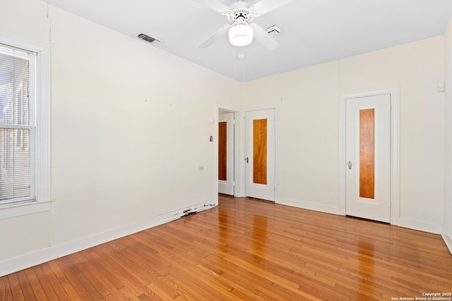 spare room with light wood-type flooring, visible vents, plenty of natural light, and ceiling fan