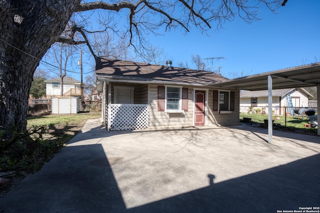 view of front of property with an outbuilding, a shed, and fence