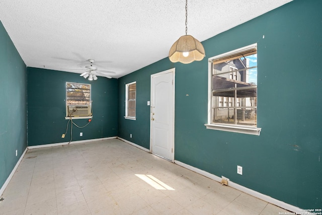 spare room with tile patterned floors, a ceiling fan, baseboards, and a textured ceiling