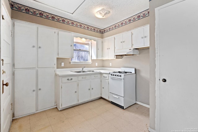 kitchen featuring under cabinet range hood, a sink, gas range gas stove, a textured ceiling, and white cabinetry