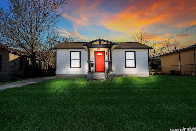 view of front of home featuring a yard and fence