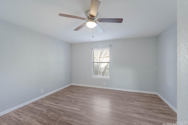 unfurnished room featuring ceiling fan, baseboards, and wood finished floors