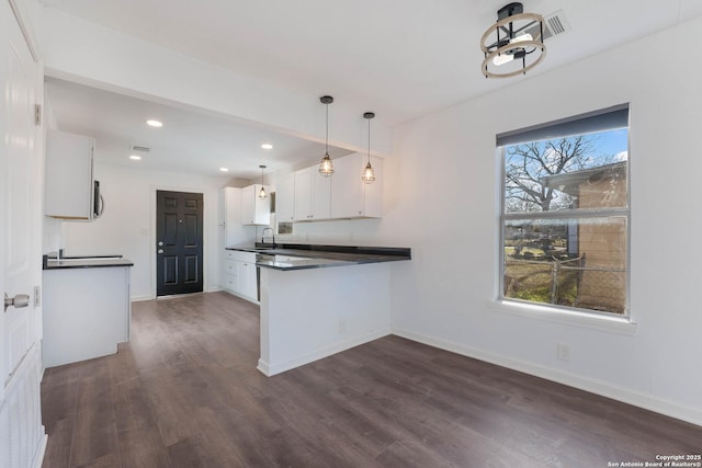 kitchen with a sink, dark countertops, and a healthy amount of sunlight