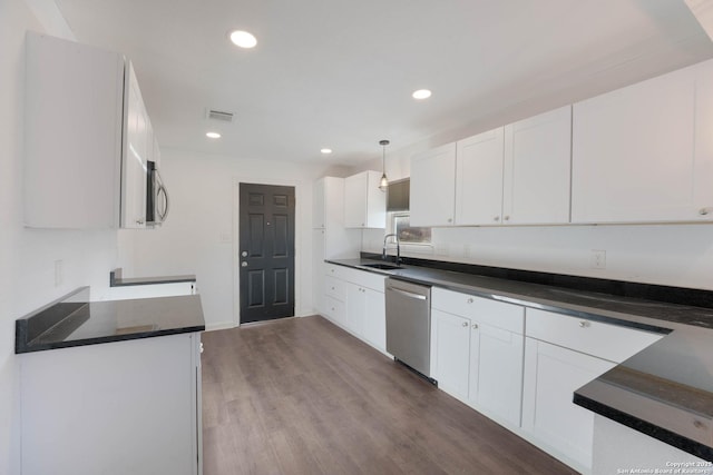 kitchen with visible vents, dark wood-type flooring, a sink, white cabinetry, and stainless steel appliances