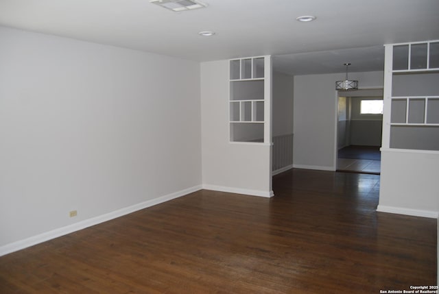 spare room with visible vents, baseboards, and wood finished floors