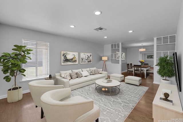 living area with visible vents, recessed lighting, baseboards, and wood finished floors