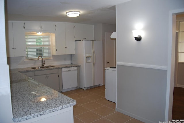 kitchen with white cabinetry, white appliances, light tile patterned floors, and a sink