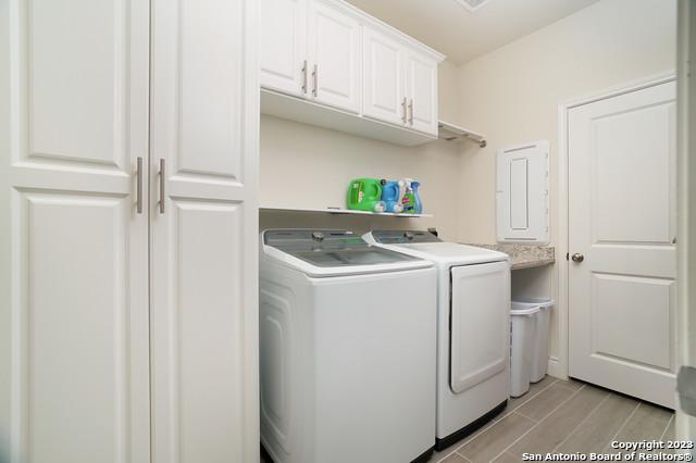 laundry room with cabinet space, washing machine and dryer, and wood tiled floor