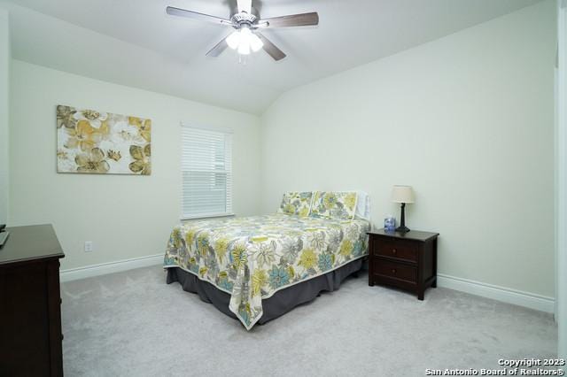 carpeted bedroom featuring baseboards, lofted ceiling, and a ceiling fan