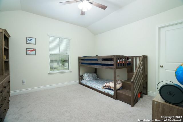 bedroom featuring baseboards, carpet, and vaulted ceiling