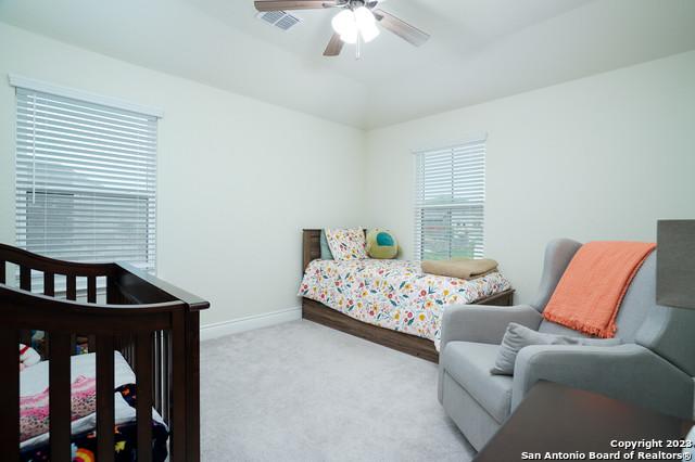 bedroom featuring carpet flooring, baseboards, visible vents, and ceiling fan