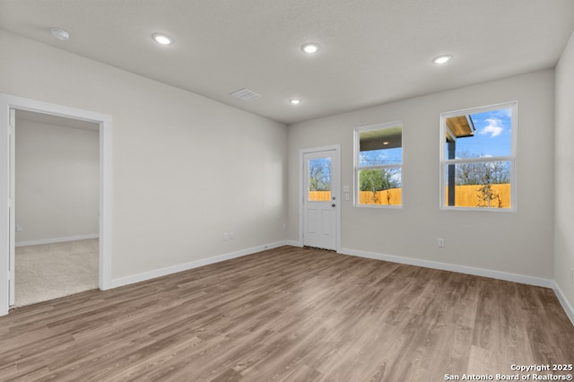 unfurnished room with visible vents, recessed lighting, baseboards, and wood finished floors