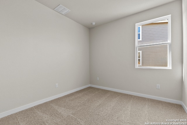 carpeted spare room featuring visible vents and baseboards