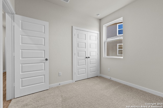 unfurnished bedroom featuring a closet, baseboards, and carpet floors