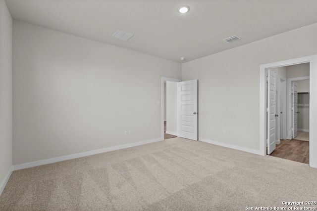 unfurnished bedroom featuring recessed lighting, visible vents, baseboards, and carpet flooring