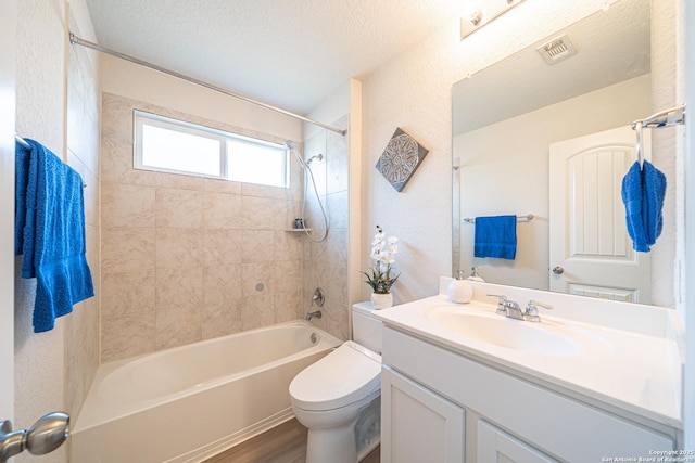 bathroom with vanity, wood finished floors, visible vents, shower / bath combination, and toilet