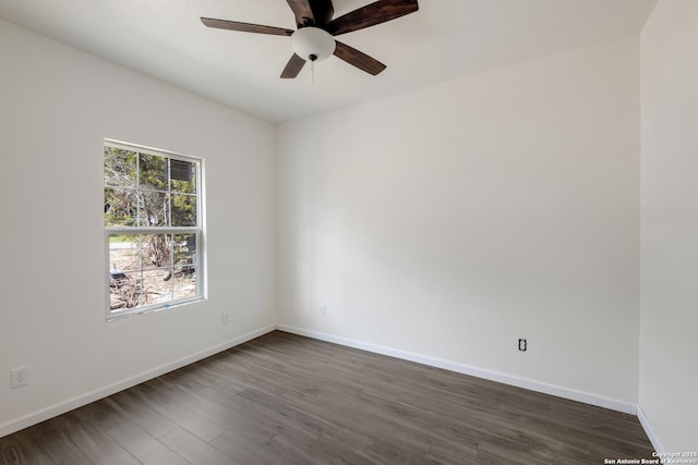 spare room featuring baseboards, dark wood-type flooring, and a ceiling fan