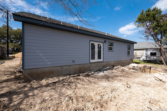 rear view of property with french doors and fence