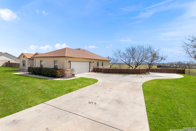 view of front facade with a front lawn, an attached garage, fence, and concrete driveway